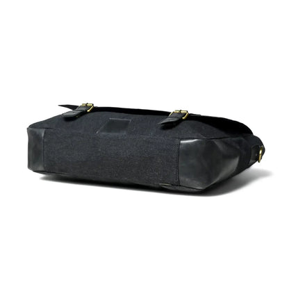 Side profile of the black leather and canvas office bag
